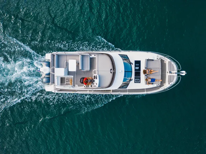  Yacht Photos Pics 2024 Jeanneau NC 1295 Fly yacht cruising on open water, aerial view.