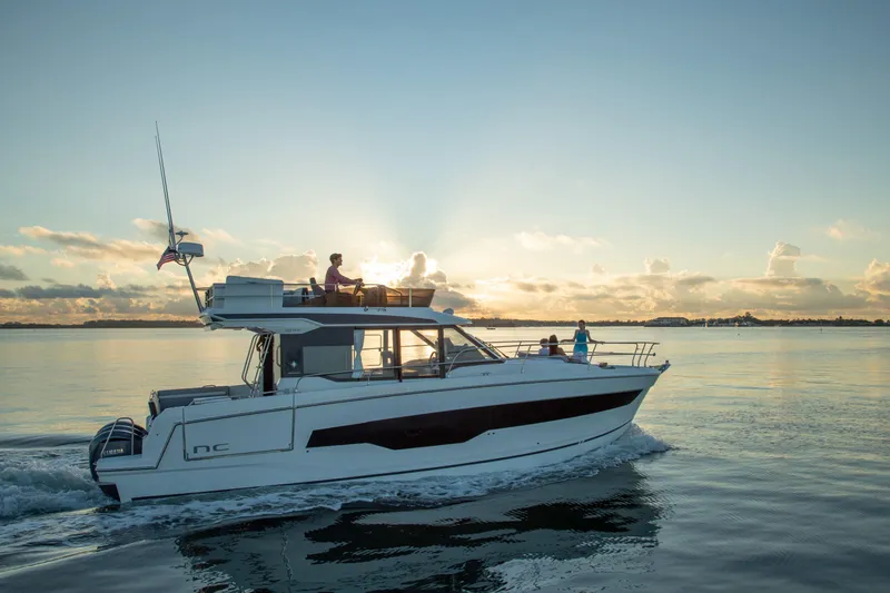  Yacht Photos Pics 2024 Jeanneau NC 1295 Fly cruising at sunset on calm waters.