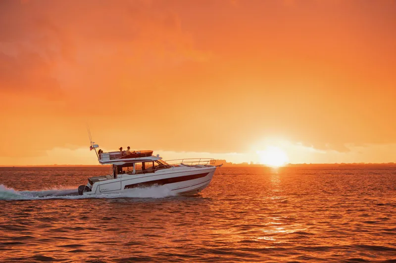  Yacht Photos Pics 2024 Jeanneau NC 1295 Fly cruising at sunset on open water.