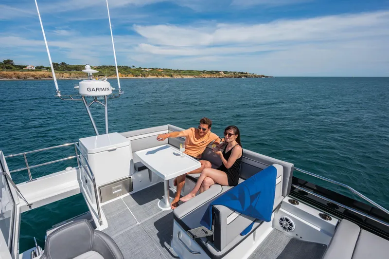  Yacht Photos Pics Couple relaxing on 2024 Jeanneau NC 1295 Fly yacht, enjoying ocean view.