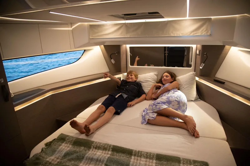  Yacht Photos Pics Children relaxing in the cozy cabin of a 2024 Jeanneau NC 1295 Fly yacht.
