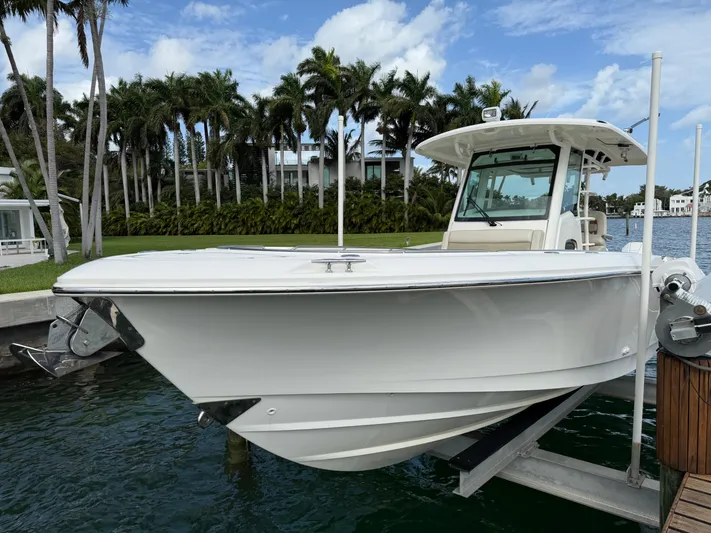 Abvios Yacht Photos Pics 2020 Boston Whaler 330 Outrage boat docked near palm trees and waterfront homes.