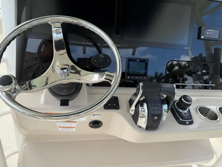 Abvios Yacht Photos Pics Control panel of a 2020 Boston Whaler 330 Outrage boat with steering wheel and controls.