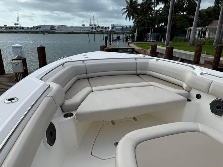 Abvios Yacht Photos Pics 2020 Boston Whaler 330 Outrage boat with spacious seating, docked by a scenic waterfront.