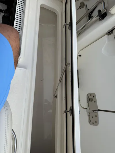 Abvios Yacht Photos Pics 2020 Boston Whaler 330 Outrage interior storage compartment with open hatch and visible hinges.