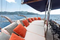 Luxurious 1993 Custom Gulet Motorsailer deck with cushioned seating and ocean view.