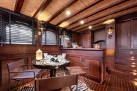 Luxurious wooden interior of 1993 Custom Gulet Motorsailer with elegant dining area and ambient lighting.