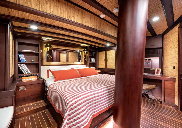 Ocean Pure Yacht Photos Pics Luxurious cabin interior of 1993 Custom Gulet Motorsailer with wood accents and cozy bedding.