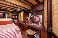 Luxurious 1993 Custom Gulet Motorsailer cabin with wooden interior and cozy bedding.