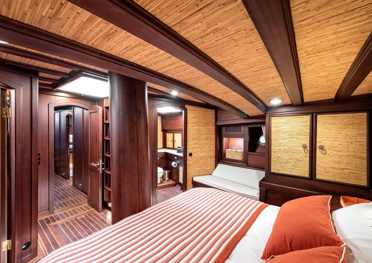 Ocean Pure Yacht Photos Pics Luxurious cabin interior of 1993 Custom Gulet Motorsailer with wood paneling and cozy bedding.