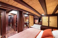 Luxurious cabin interior of 1993 Custom Gulet Motorsailer with wood paneling and cozy bedding.