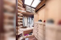 Luxurious wooden closet on 1993 Custom Gulet Motorsailer with clothes, shoes, and accessories.