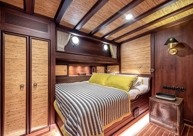 Ocean Pure Yacht Photos Pics Luxurious cabin interior of 1993 Custom Gulet Motorsailer with wood paneling and cozy bedding.