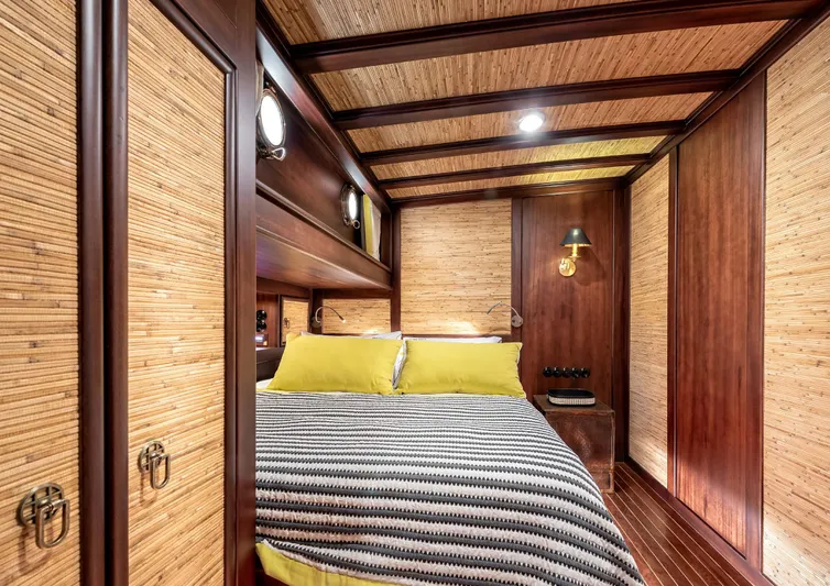 Ocean Pure Yacht Photos Pics Luxurious cabin interior of 1993 Custom Gulet Motorsailer with wood paneling and cozy bedding.