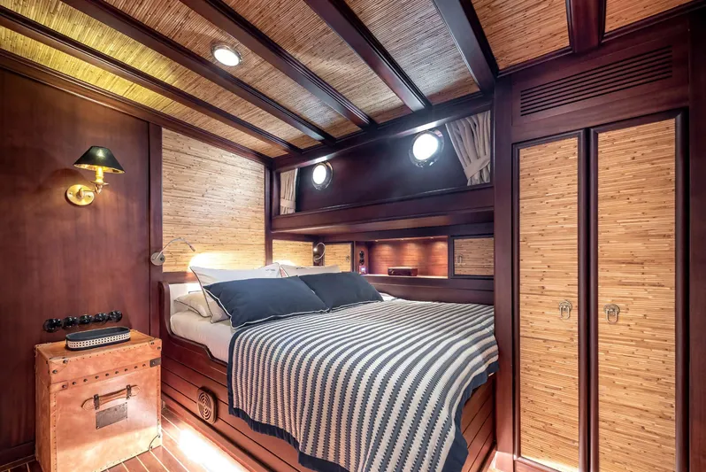 Ocean Pure Yacht Photos Pics Luxurious cabin interior of 1993 Custom Gulet Motorsailer with wood paneling and cozy bed.