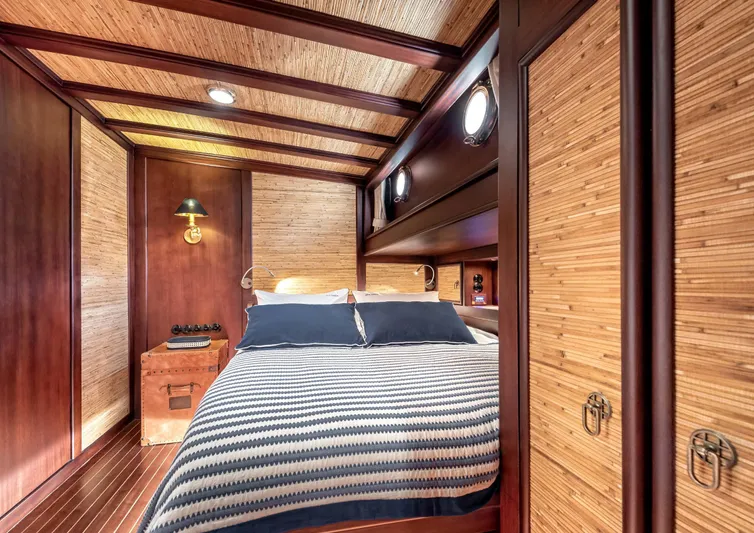 Ocean Pure Yacht Photos Pics Luxurious cabin interior of 1993 Custom Gulet Motorsailer with wood paneling and cozy bedding.