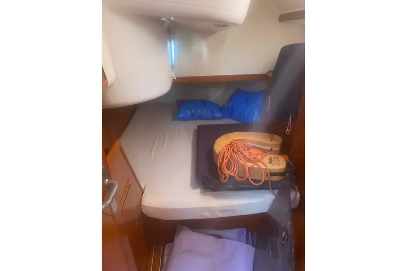  Yacht Photos Pics Cozy cabin interior of 2003 Jeanneau Sun Odyssey 45.2 sailboat with bedding and life jackets.