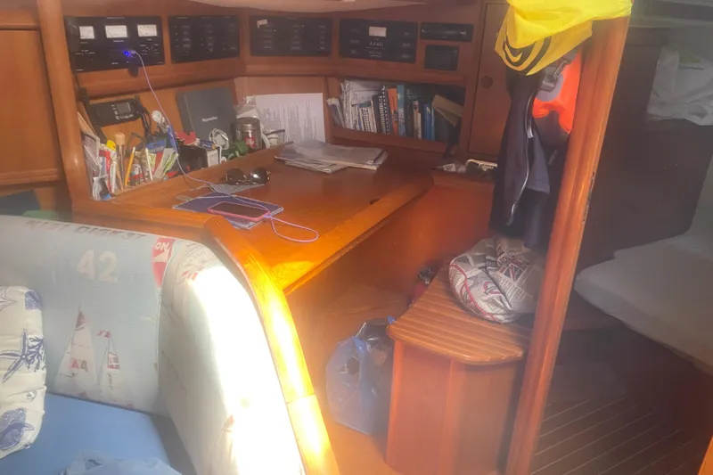  Yacht Photos Pics Cozy interior of 2003 Jeanneau Sun Odyssey 45.2 sailboat with navigation station and seating area.