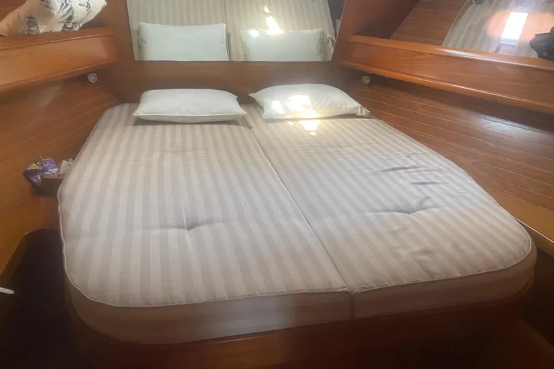 Yacht Photos Pics Cozy cabin interior of 2003 Jeanneau Sun Odyssey 45.2 with striped bedding.