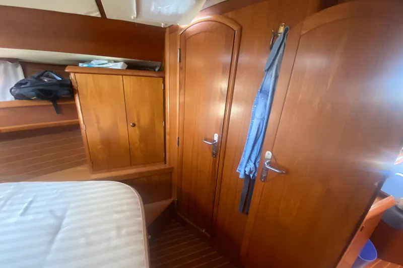  Yacht Photos Pics Interior of 2003 Jeanneau Sun Odyssey 45.2 yacht with wooden cabinetry and doors.