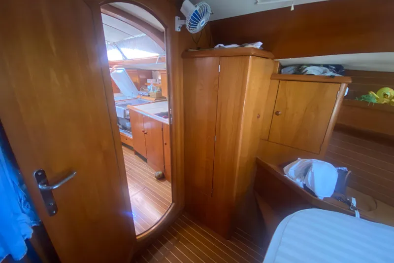  Yacht Photos Pics Interior of 2003 Jeanneau Sun Odyssey 45.2 sailboat with wooden cabinetry and cozy layout.