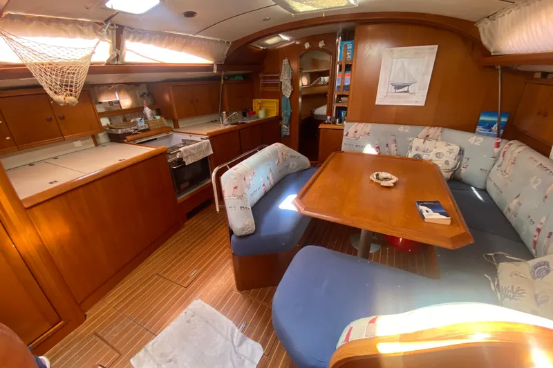  Yacht Photos Pics Interior of 2003 Jeanneau Sun Odyssey 45.2 sailboat with cozy dining area and kitchen.
