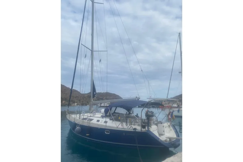  Yacht Photos Pics 2003 Jeanneau Sun Odyssey 45.2 sailboat docked in a serene marina setting.