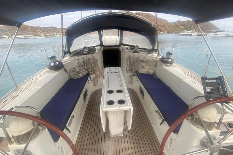 Yacht Photos Pics Cockpit of 2003 Jeanneau Sun Odyssey 45.2 sailboat with blue seating and wooden deck.