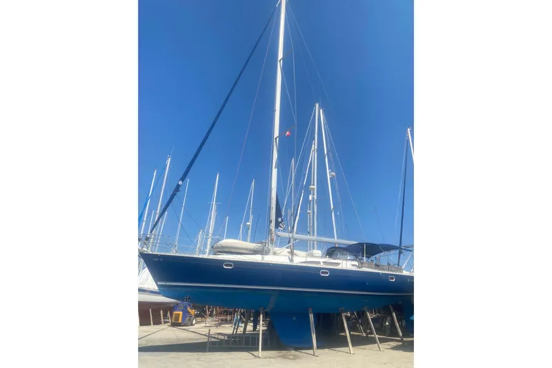  Yacht Photos Pics 2003 Jeanneau Sun Odyssey 45.2 sailboat on dry dock under clear blue sky.