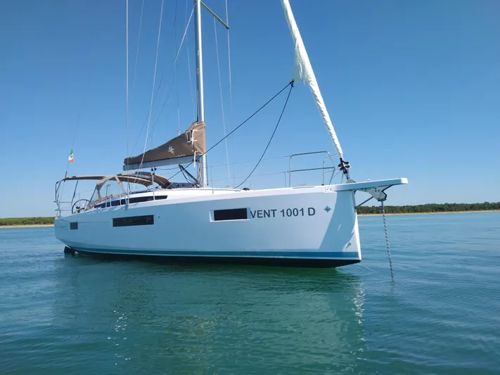 Vanilla IV Yacht Photos Pics 2023 Jeanneau Sun Odyssey 410 sailboat on calm water under clear blue sky.