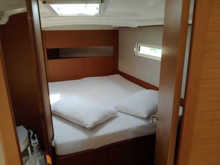 Vanilla IV Yacht Photos Pics Cozy cabin interior of 2023 Jeanneau Sun Odyssey 410 yacht with bed and window.