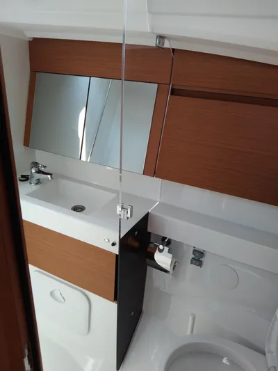 Vanilla IV Yacht Photos Pics 2023 Jeanneau Sun Odyssey 410 bathroom with modern fixtures and wooden accents.