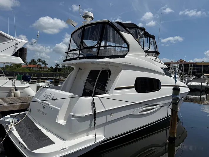  Yacht Photos Pics 2002 Silverton 410 Sport Bridge yacht docked at marina under blue sky.