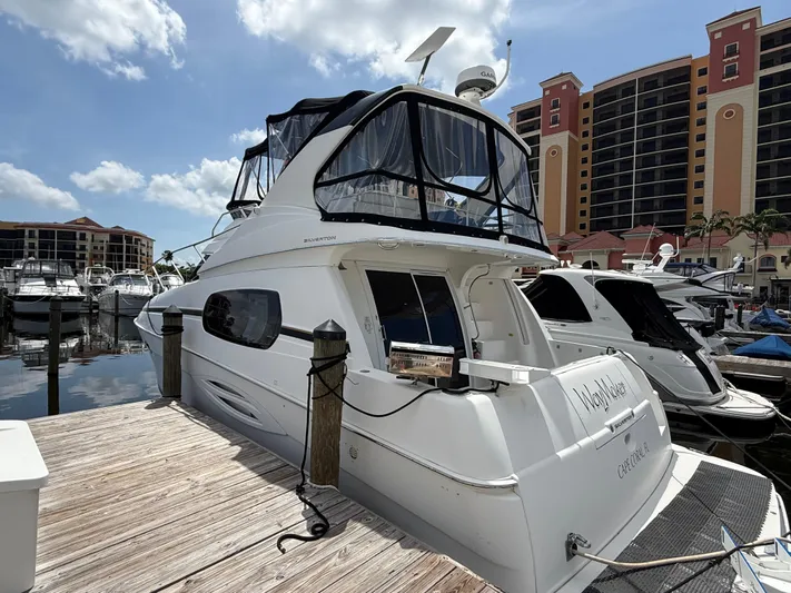  Yacht Photos Pics 2002 Silverton 410 Sport Bridge yacht docked at marina, sunny day, luxury boats in background.