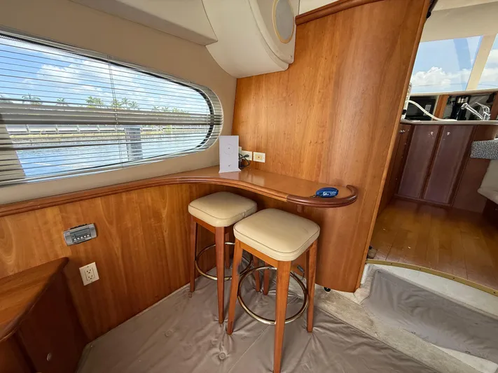  Yacht Photos Pics Interior of 2002 Silverton 410 Sport Bridge with wooden bar and stools, overlooking water.