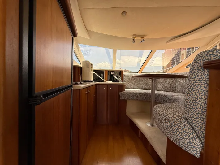  Yacht Photos Pics Interior of 2002 Silverton 410 Sport Bridge with wood cabinetry and curved seating area.