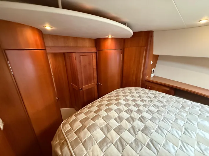  Yacht Photos Pics Luxurious cabin interior of 2002 Silverton 410 Sport Bridge with wood paneling and cozy bedding.