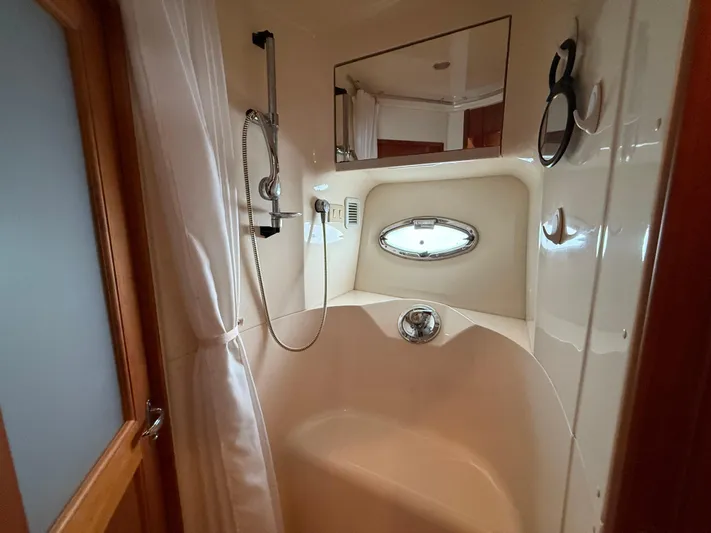  Yacht Photos Pics Shower area in 2002 Silverton 410 Sport Bridge yacht with curtain and porthole window.