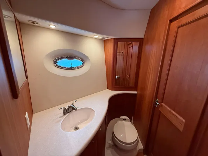  Yacht Photos Pics Luxurious bathroom in 2002 Silverton 410 Sport Bridge yacht with wood accents and porthole window.