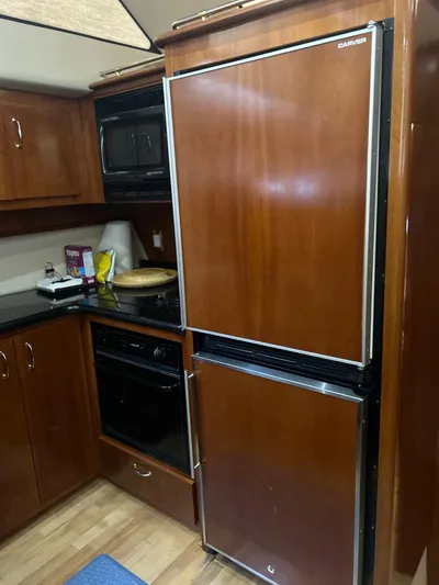  Yacht Photos Pics Kitchen area of 2003 Carver 466 Motor Yacht with wood cabinetry and appliances.