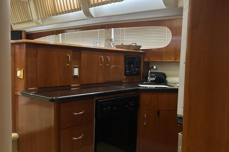  Yacht Photos Pics Luxurious kitchen interior of 2003 Carver 466 Motor Yacht with wood cabinetry and modern appliances.