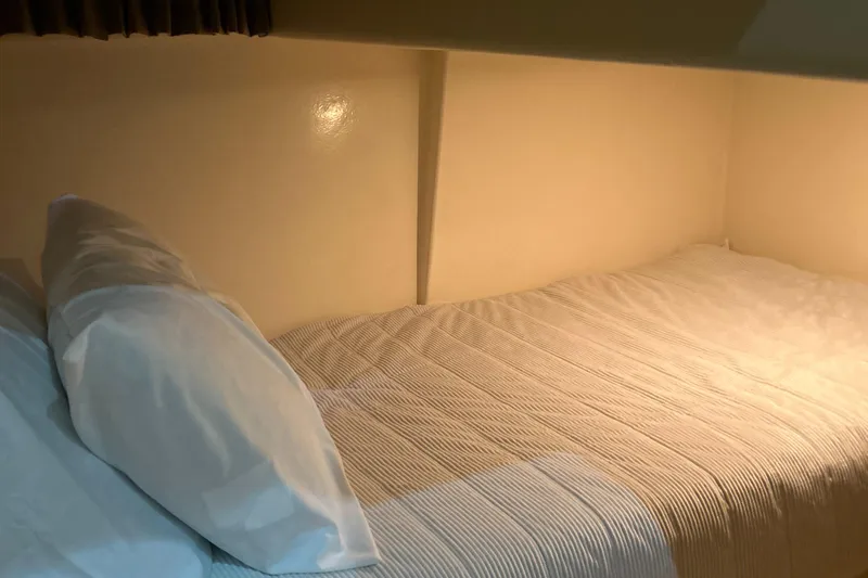  Yacht Photos Pics Cozy cabin bed in 2003 Carver 466 Motor Yacht, featuring soft lighting and comfortable bedding.