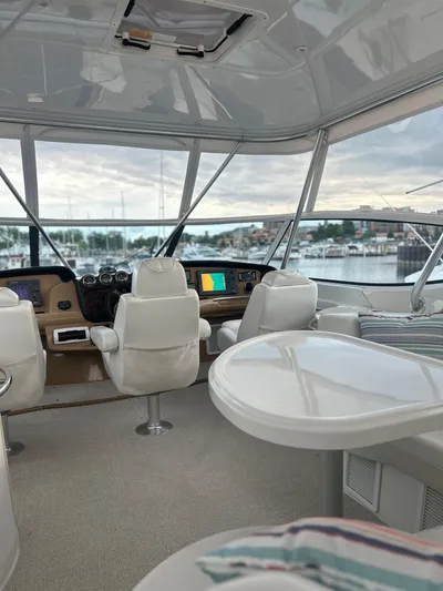  Yacht Photos Pics 2003 Carver 466 Motor Yacht interior with helm, white seating, and marina view.