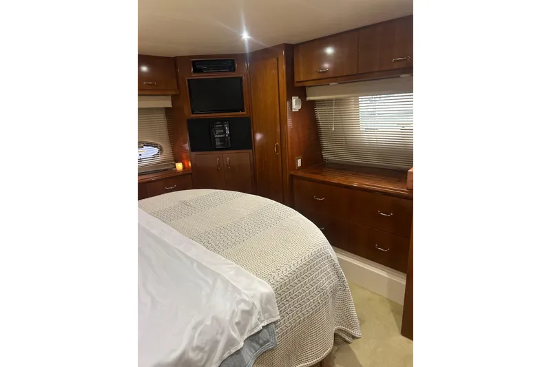  Yacht Photos Pics Luxurious bedroom interior of 2003 Carver 466 Motor Yacht with wood cabinetry and cozy bedding.