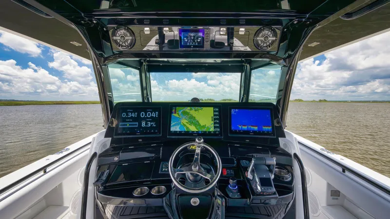 Traveller Yacht Photos Pics Cockpit view of 2021 HCB Suenos boat with advanced navigation displays on a sunny day.