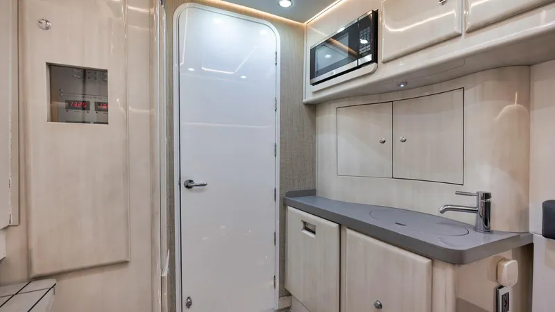 Traveller Yacht Photos Pics 2021 HCB Suenos interior with modern kitchenette, featuring cabinets, sink, and microwave.
