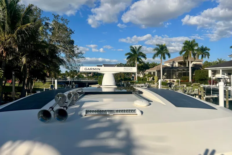  Yacht Photos Pics 2023 Scout 350 LXZ boat with Garmin radar, docked near palm trees and houses.
