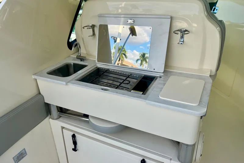  Yacht Photos Pics 2023 Scout 350 LXZ boat kitchenette with sink, stove, and cutting board.