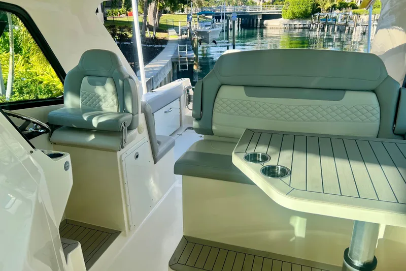  Yacht Photos Pics 2023 Scout 350 LXZ boat interior with luxurious seating and table, dockside view.