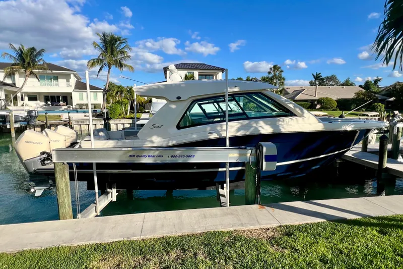  Yacht Photos Pics 2023 Scout 350 LXZ boat docked in a scenic waterfront setting.